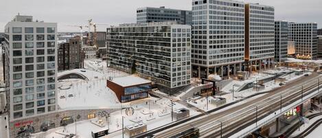 Ein modernes Stadtgebiet mit Hochhäusern, einer Straßenbahnschleife und einer schneebedeckten Fläche.