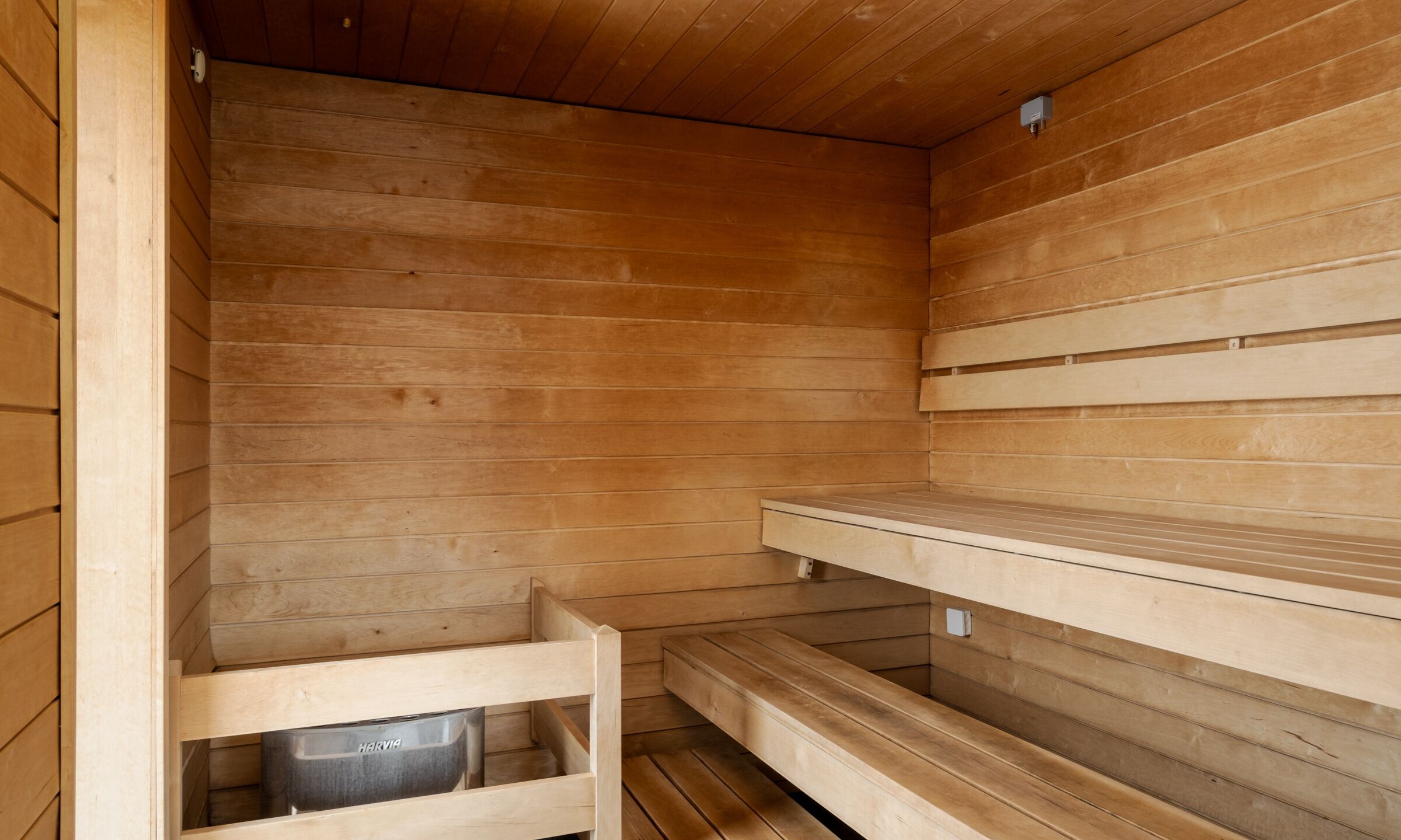 A sauna room with wooden walls and benches.