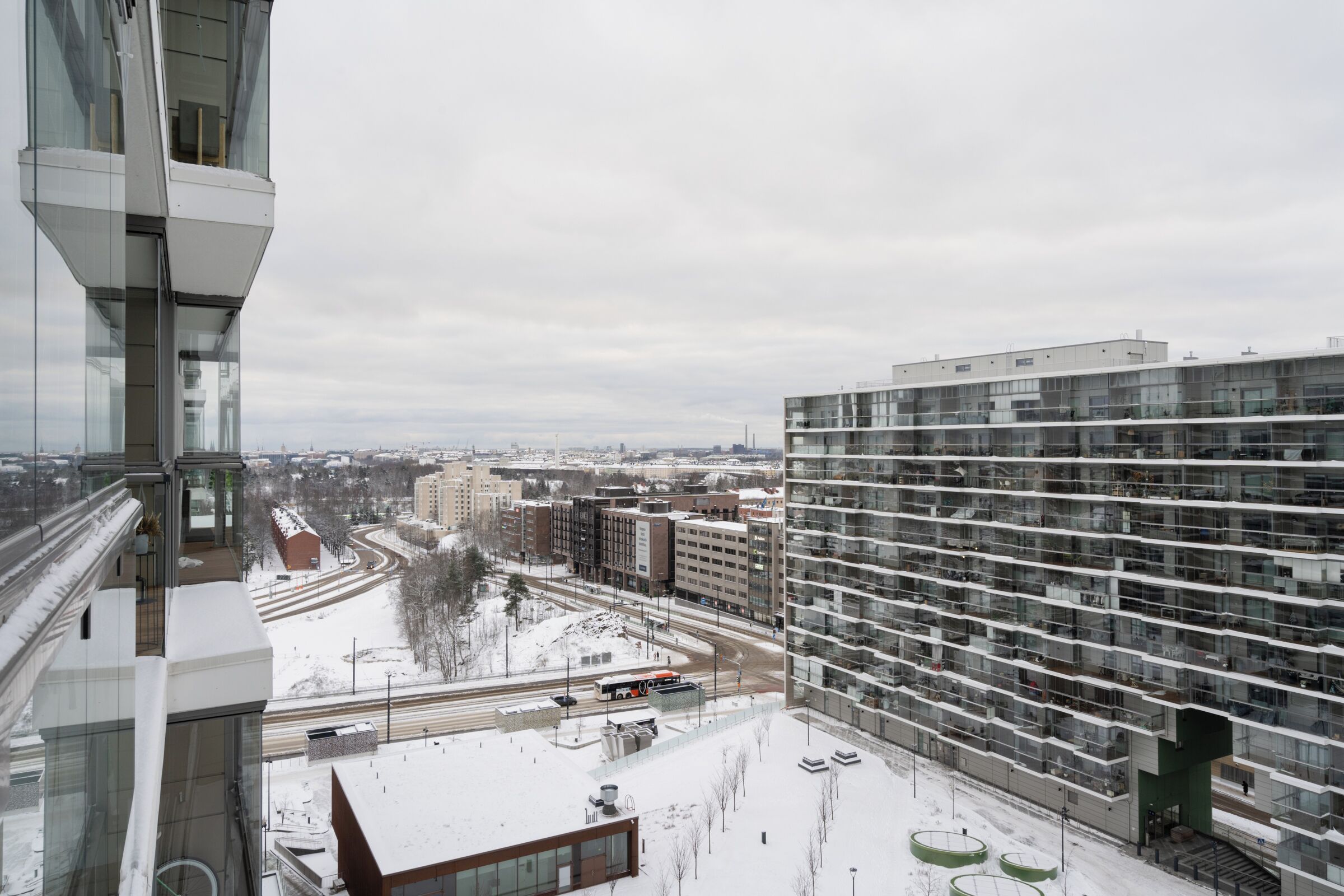 Un edificio de gran altura con varios pisos, ventanas amplias y suelo cubierto de nieve.