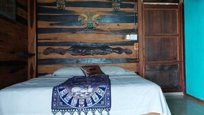 A room with a bed, wooden headboard, and a blue wall. - Cabañas Huay (Huay-Pix)