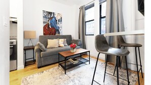 Ein modernes Wohnzimmer mit einem grauen Sofa, einem Couchtisch und einem Gemälde an der Wand.