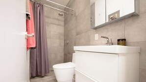 Ein modernes Badezimmer mit Dusche, Toilette und Waschbecken.