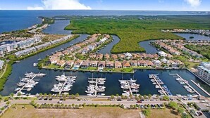An aerial view of a marina with boats docked, surrounded by residential buildings and a large body of water. - Free Golf Cart Rental in 2026! Bayfront Townhouse w/Heated Pool, HotTub, Beach (Ruskin)