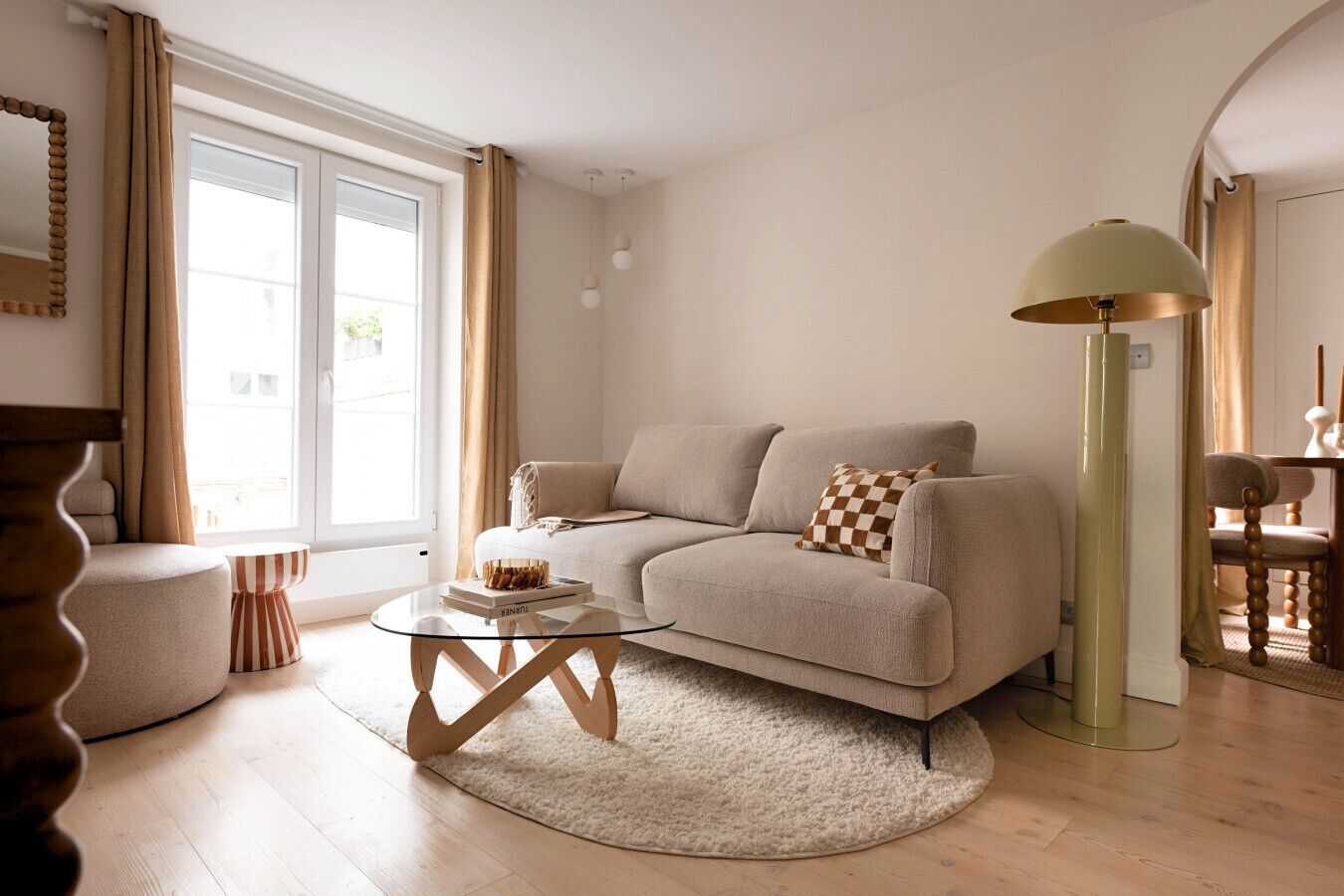 Un salon avec un canapé, une table basse, une lampe et un fauteuil.