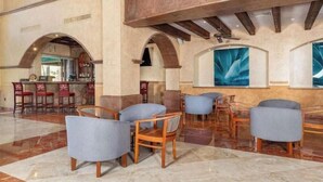 Eine Lobby mit Barbereich, Sitzgelegenheiten mit gepolsterten Stühlen und einem Marmorboden.