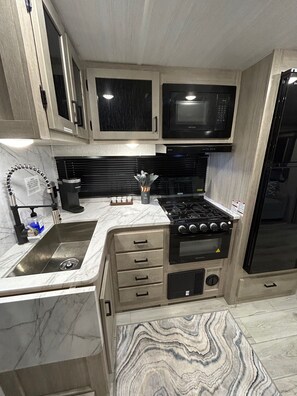 Fridge, microwave, oven, stovetop - The Lake Escape RV Meets The Beach (Foley)