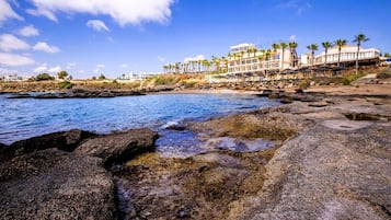 Na praia, espreguiçadeiras, toalhas de praia