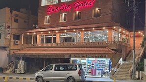 A building with a prominent "Sun Set Hotel" sign, featuring multiple windows and a balcony. - Sunset hotel (Wadi Musa)
