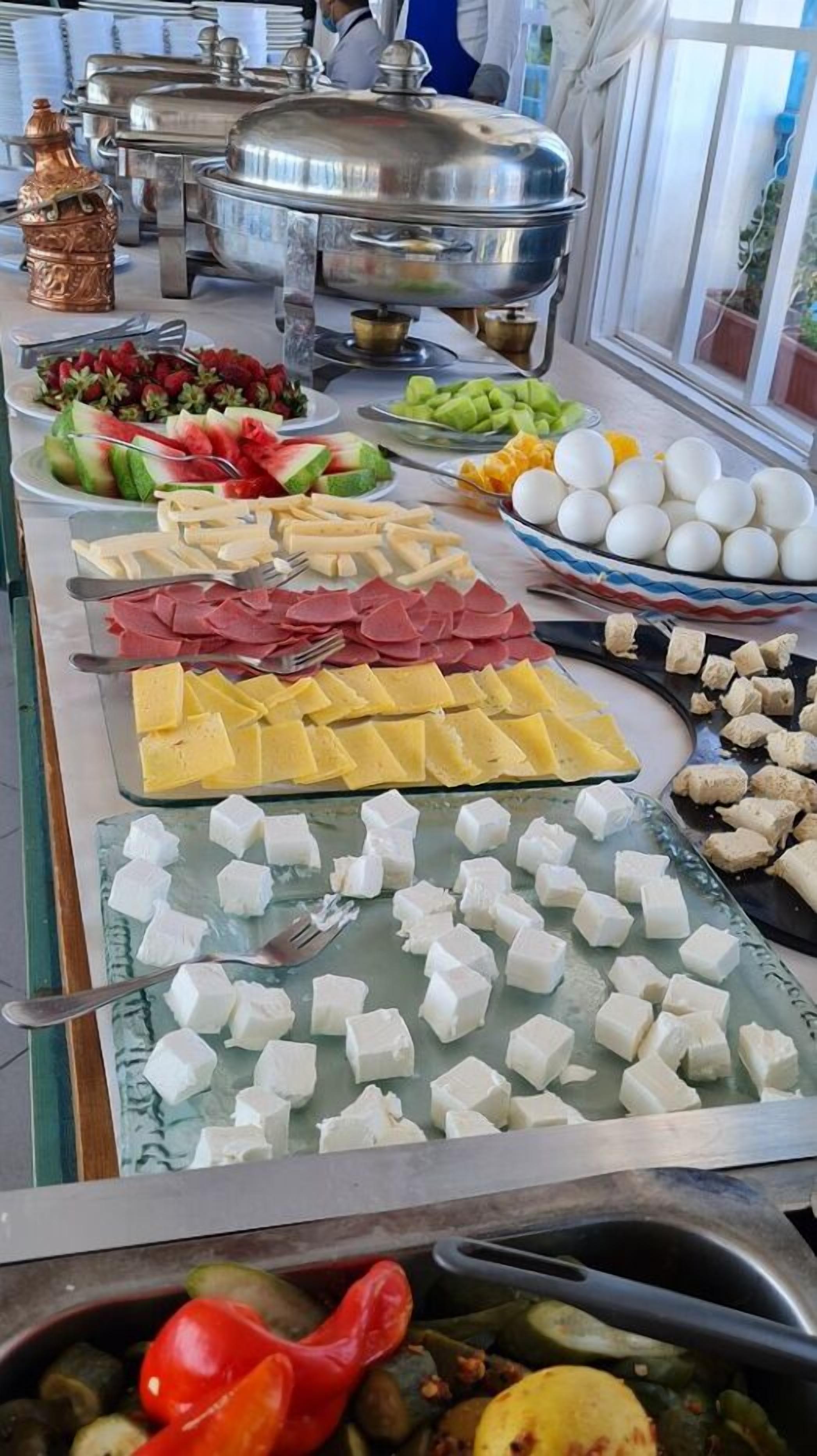 A buffet with various food items including fruits, cheeses, meats, and vegetables.