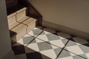 A staircase with wooden steps and a checkered floor pattern. - The Penrose Suites (Saint Marys)
