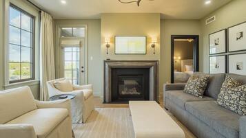 A living room with a fireplace, a sofa, a chair, and a coffee table.