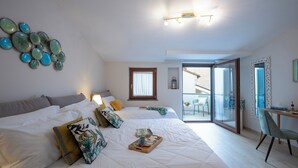 Une chambre moderne avec un grand lit, un bureau et un balcon.