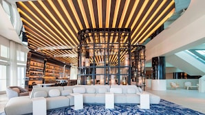 A modern interior with a large sectional sofa, a patterned rug, and a unique ceiling design. - Lux Two BR Suite at W Fort Lauderdale (Fort Lauderdale)