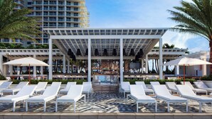 A poolside area with white lounge chairs, umbrellas, and a bar area. - Lux Two BR Suite at W Fort Lauderdale (Fort Lauderdale)
