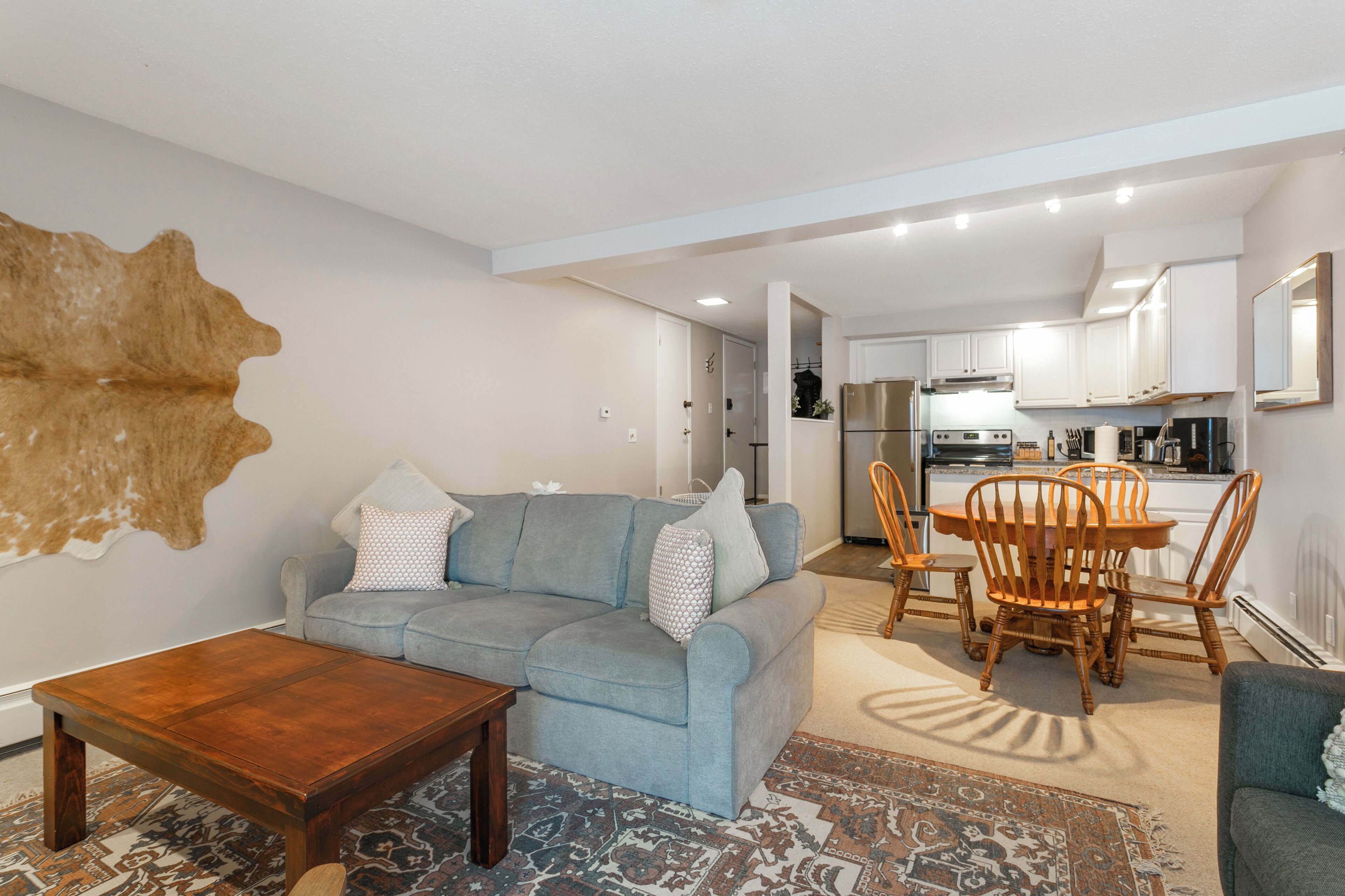 Una sala de estar moderna con un sofá, una mesa de centro y un comedor con sillas y una mesa.