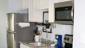 A modern kitchen with stainless steel appliances, white cabinets, and a granite countertop. - 1 Bedroom Apartment in North Charleston (North Charleston)