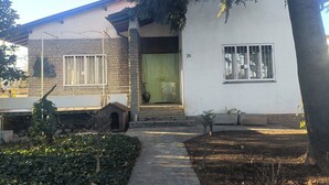A two-story house with a stone facade, a green door, and a window with bars. - B&B Bam Bam (Bergamo)