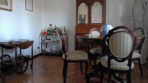 A dining area with wooden furniture, a china cabinet, and a statue. - B&B Bam Bam (Bergamo)