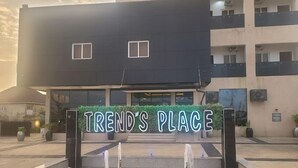 Ein modernes Gebäude, vor dem ein Schild mit der Aufschrift "TREND'S PLACE" zu sehen ist.