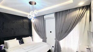 Ein modernes Schlafzimmer mit einem großen Bett, einem Schreibtisch und einer Deckenleuchte.