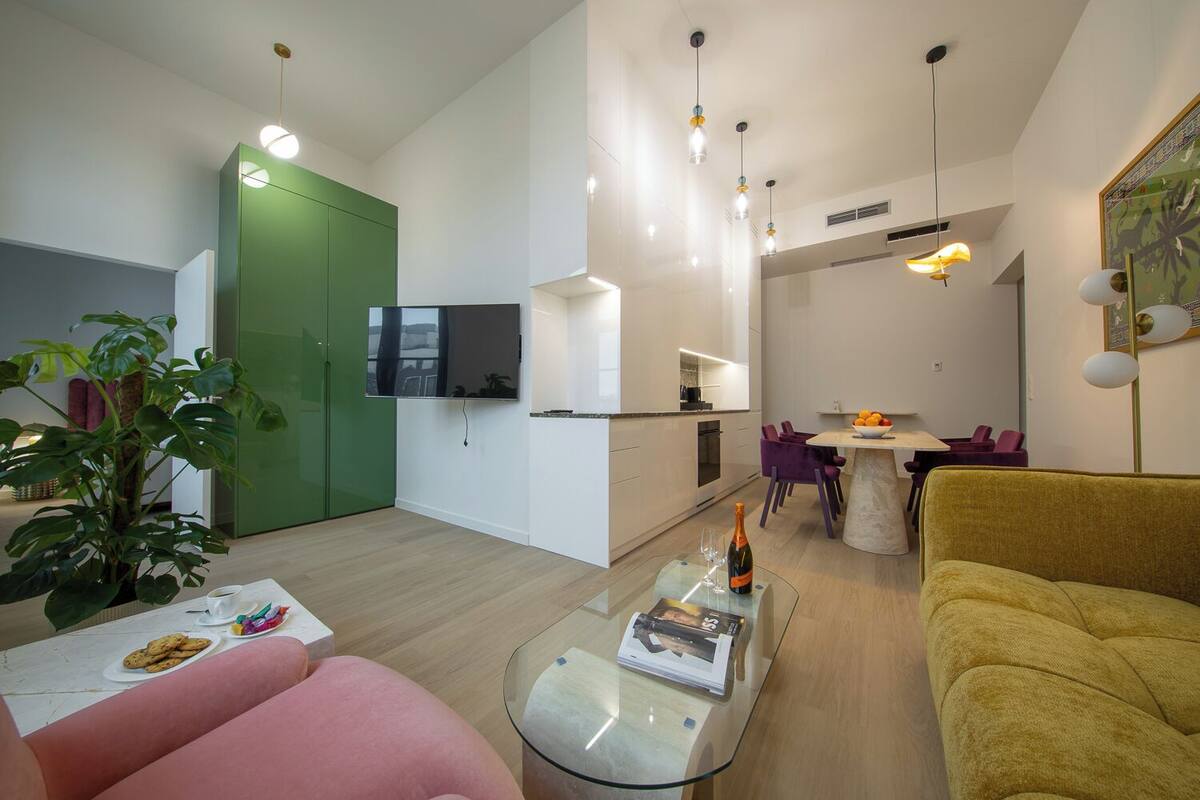 Un salon moderne comprenant un canapé, une table basse et un coin repas avec une table et des chaises.