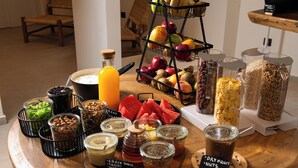 A breakfast buffet with various food items and condiments. - Mazee Paros (Paros)