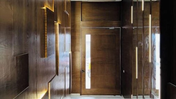 Un couloir moderne avec des lambris en bois et un sol en marbre.