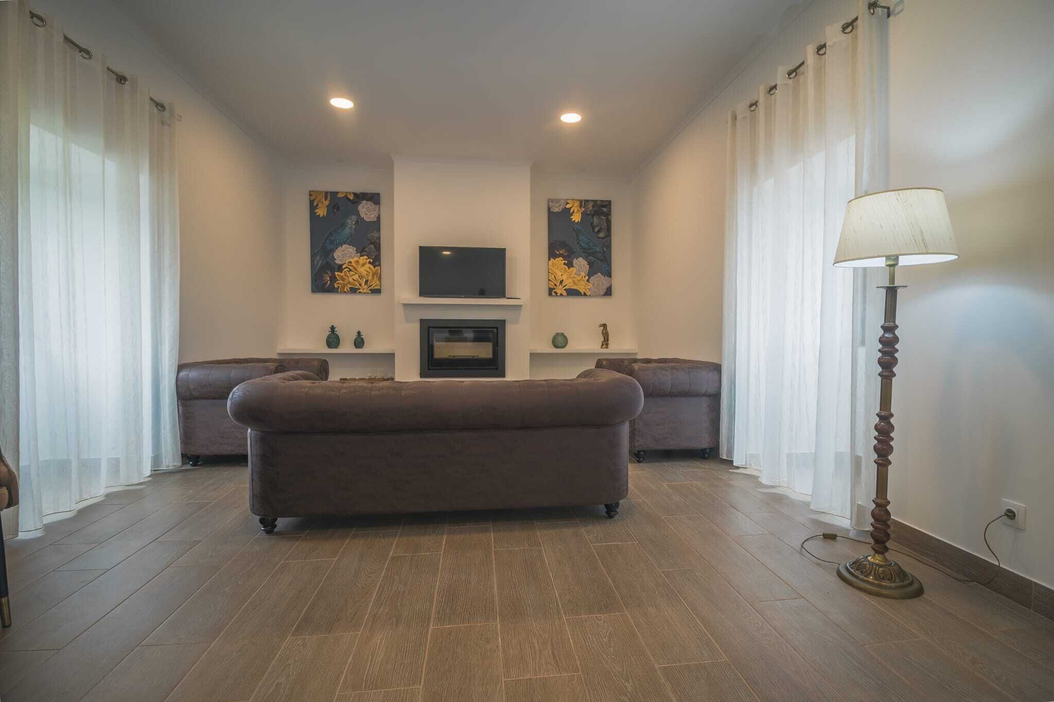 Una sala de estar con un sofá, una televisión y decoración en la pared.