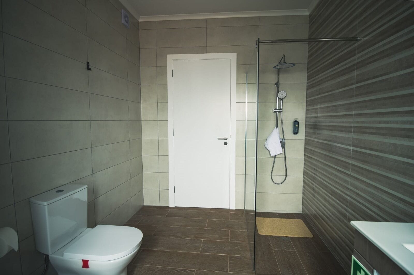 Ein Badezimmer mit Toilette, Dusche und einer Tür.