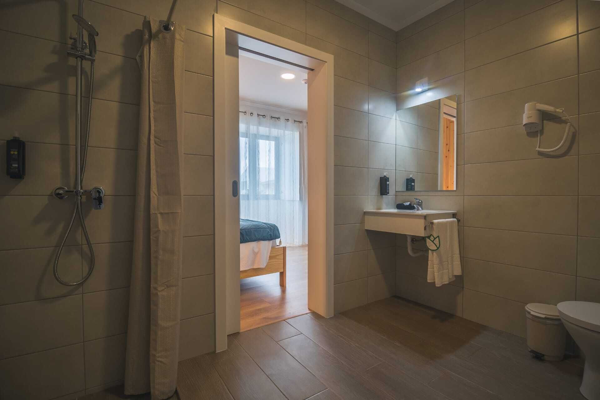 A modern bathroom with a shower, a sink, and a toilet.