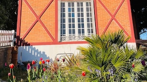 Un bâtiment à deux étages aux couleurs rouge et blanche, doté d’une fenêtre centrale et d’un petit balcon.