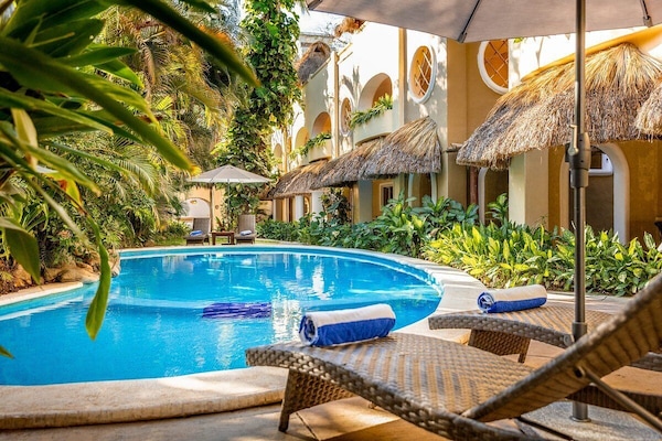 Una piscina al aire libre, sillones reclinables de piscina