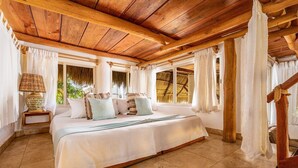 A spacious bedroom with a large bed, wooden ceiling beams, and a view of the outdoors. - Casa Real Sayulita Hotel Boutique (Sayulita)