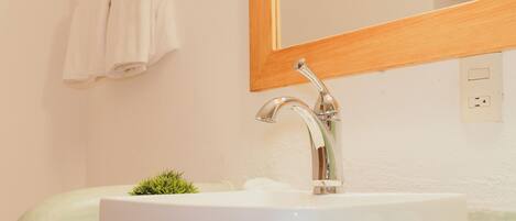 A bathroom with a white sink, a mirror, and a towel rack.