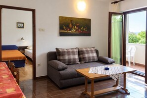 A cozy living area with a sofa, a small table, and a painting on the wall. - Apartment Mare in Krk Harbor, close to the Beach and Center, Air conditioned, Parking for two Cars (Krk)