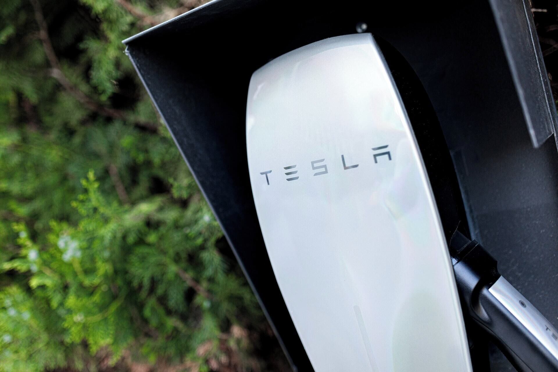 A Tesla car's charging station with a visible Tesla logo.