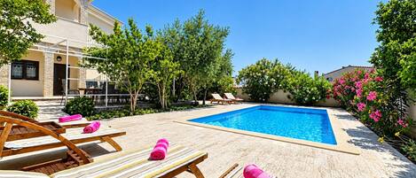 A poolside area with lounge chairs and a swimming pool.
