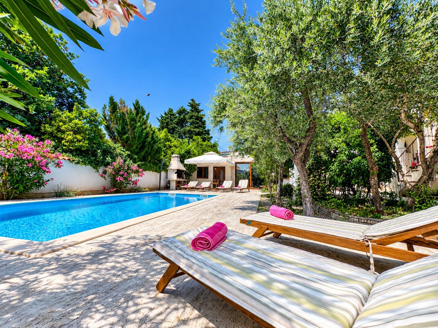 A poolside area with lounge chairs and a pergola.