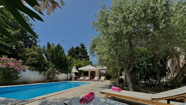 A poolside area with lounge chairs and a barbecue grill. - Apartment KrisTina with pool, family friendly, WiFi, parking, pets allowed (Krk)