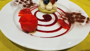 Une assiette à dessert ornée d’un motif en spirale, avec des fraises et une petite tarte.
