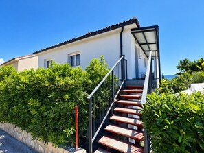 Um edifício moderno com escadas que levam a uma área externa coberta.