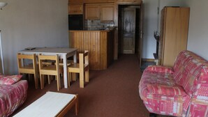 A compact living space with a kitchenette, a dining area with a table and chairs, and a sofa. - Yeti Yt76b1 SUN & View 6 Pers (Chatel)