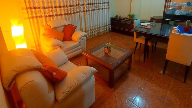 Una sala de estar con sofá, mesa de centro y comedor.