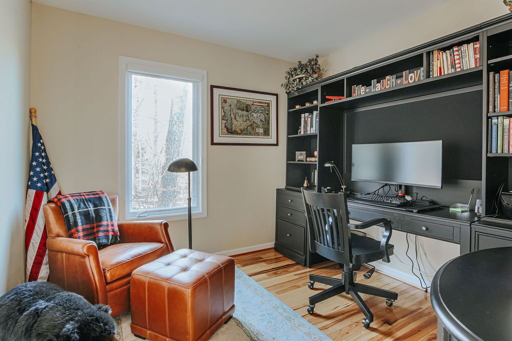 Ein Arbeitszimmer mit Schreibtisch, Stuhl und Bücherregal.