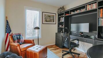 Ein Arbeitszimmer mit Schreibtisch, Stuhl und Bücherregal.
