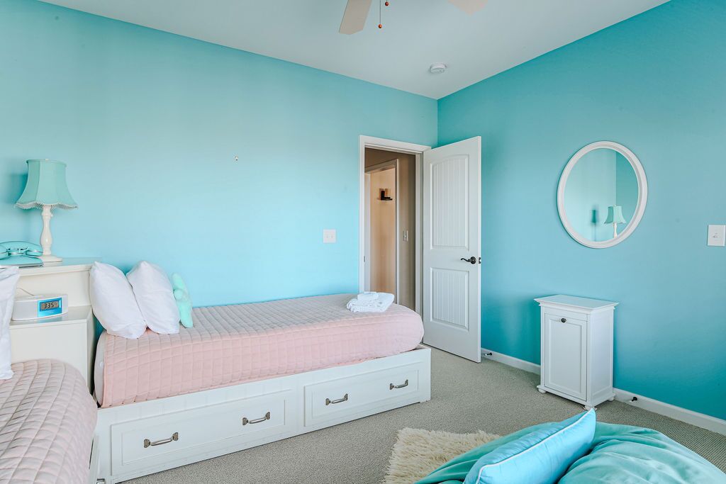 Une chambre à coucher comprenant un lit, des tables de chevet, une commode, un miroir et une armoire.