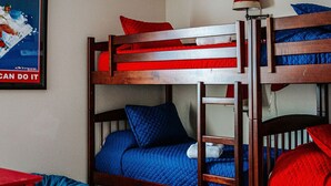 A bunk bed room with a ceiling fan, a poster on the wall, and a patterned rug. - Red White & WTG: Hot Tub, 5 Bedrooms! (Wintergreen Resort)