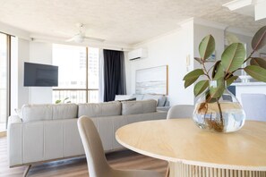 A modern living room with a sofa, a round table, and a plant.