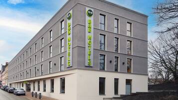 Un hôtel moderne, avec une façade sobre, de nombreuses fenêtres et une enseigne bien visible pour la chaîne B&B Hotels.