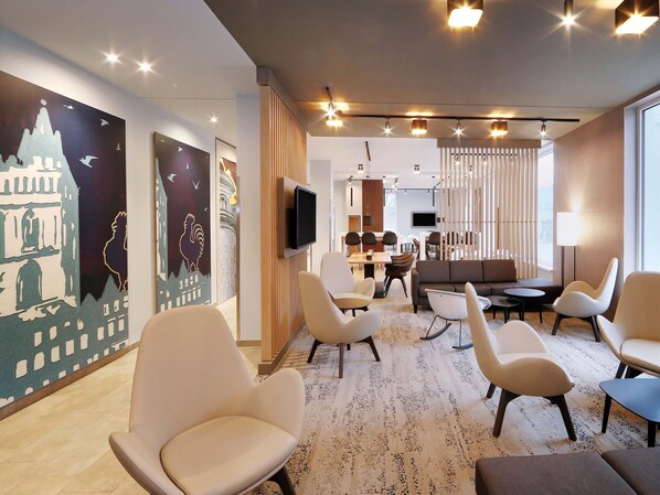 Eine moderne Hotelhalle mit Essbereich, Sitzgelegenheiten und Kunstwerken an den Wänden.